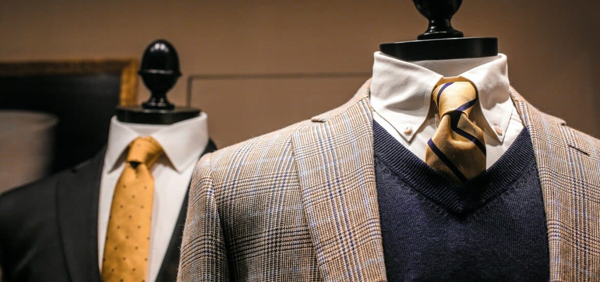 Dandy fancy jackets with shiny ties on dummies in showroom of contemporary male shop