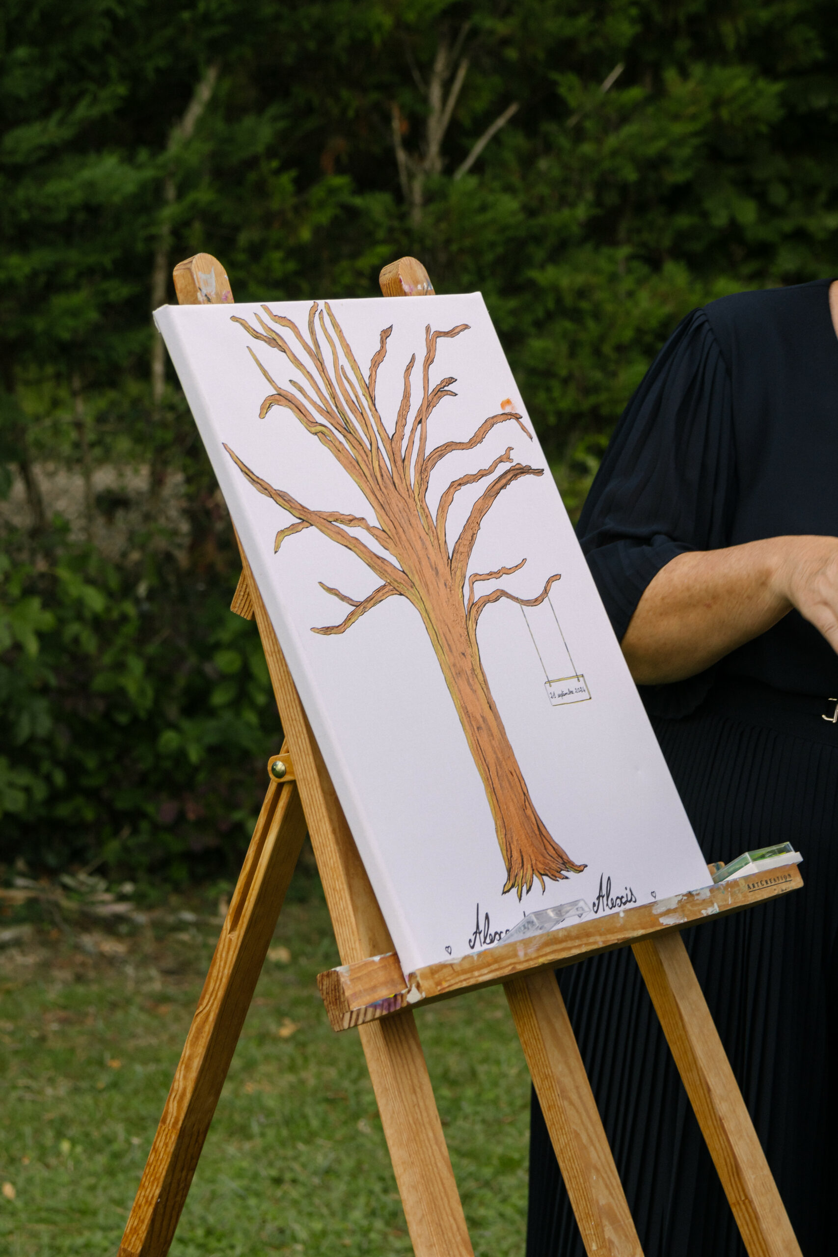 Invitée laissant son empreinte sur l'arbre à empreintes de mariage posé sur un chevalet