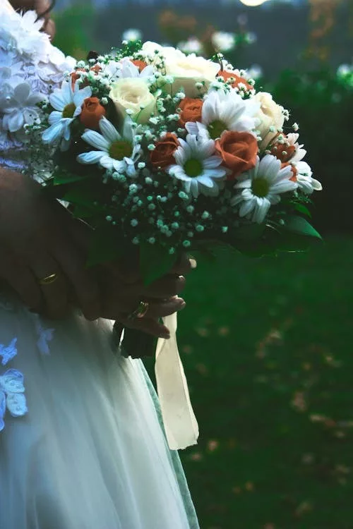 Bouquet de mariée champêtre avec marguerites et roses dans un jardin