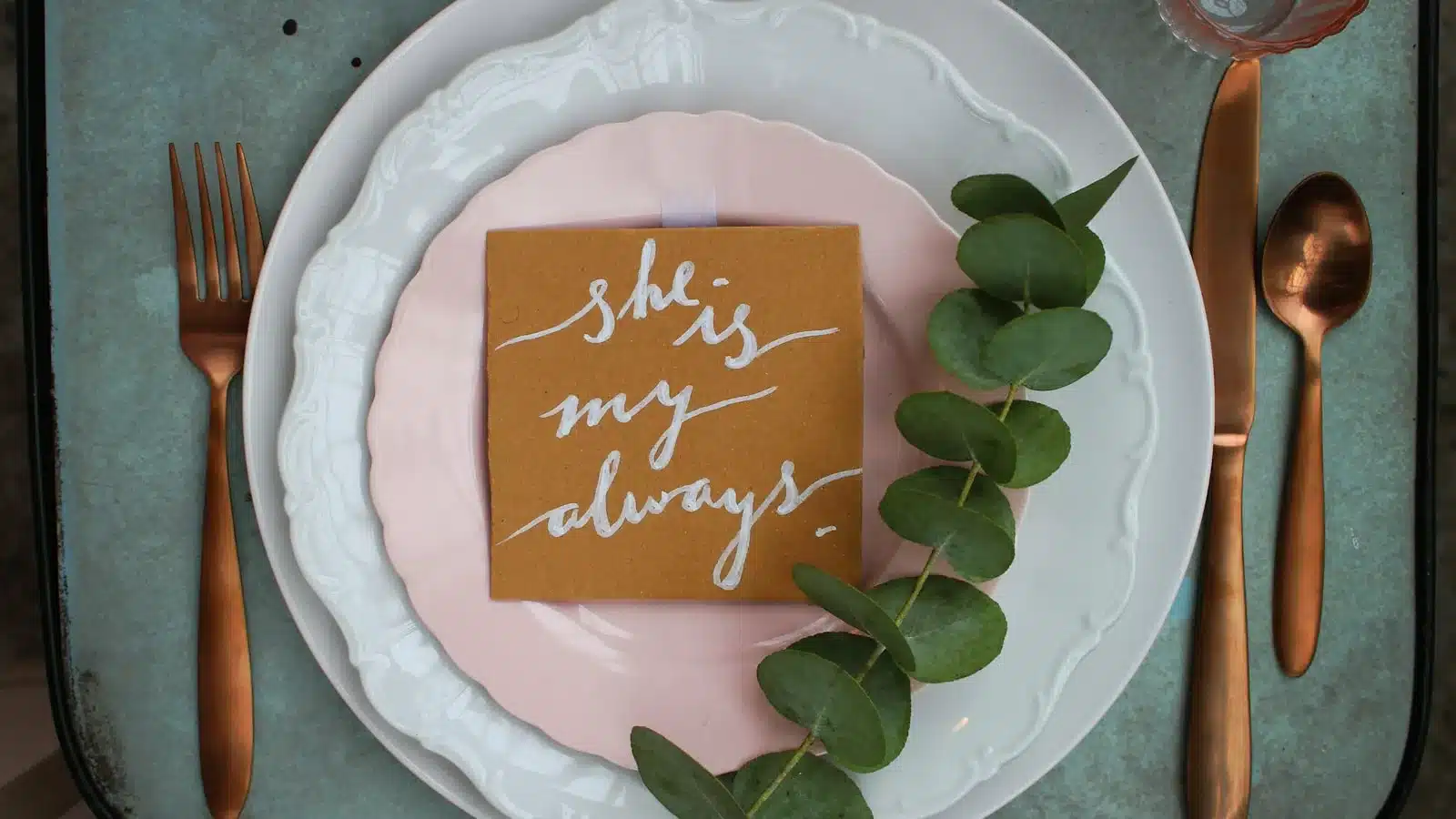 Marque-place mariage en papier kraft avec calligraphie blanche et eucalyptus