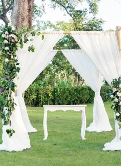 Arche de mariage DIY en jardin avec voilages blancs et fleurs
