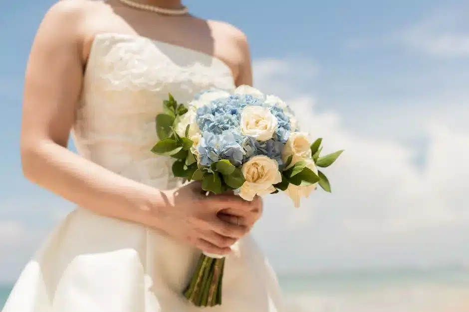 Bouquet de mariee en hortensias bleus et roses creme tenu par une mariee