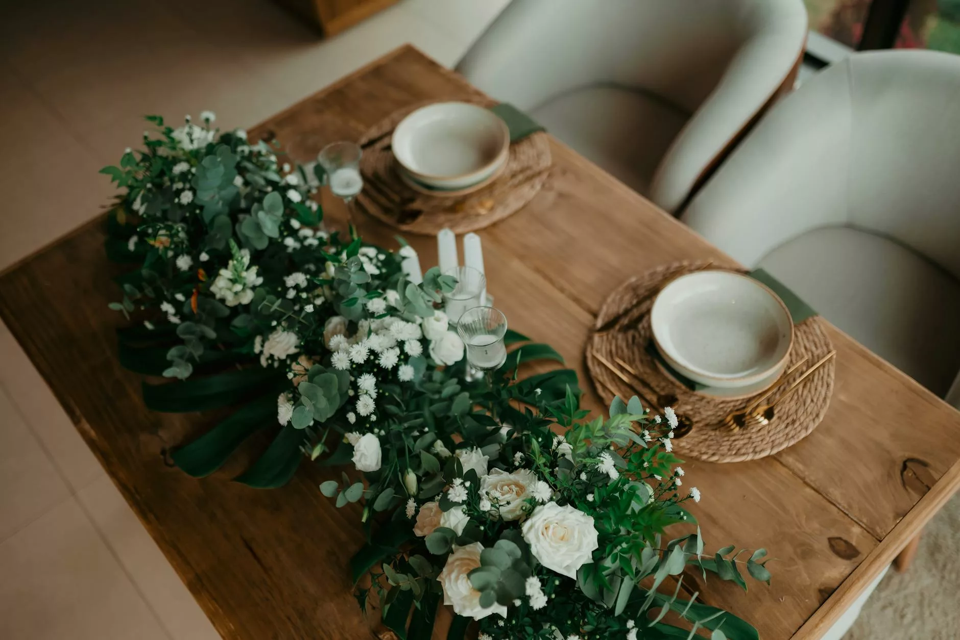 Centre de table mariage fleuriste professionnel : chemin de table fleuri pivoines et eucalyptus sur table en bois
