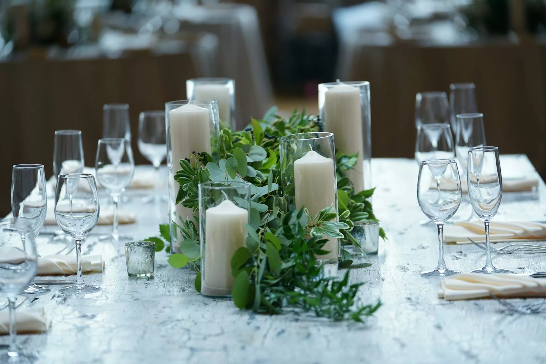Centre de table mariage 100 pour cent végétal : bougies piliers entourées de verdure et eucalyptus