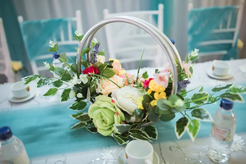 Composition florale en panier avec roses et verdure sur table de mariage