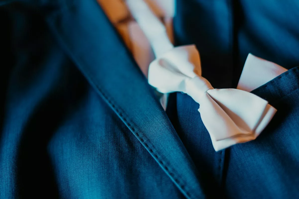 Nœud papillon ivoire posé sur un costume bleu marine, exemple d'accord de couleurs réussi pour un mariage