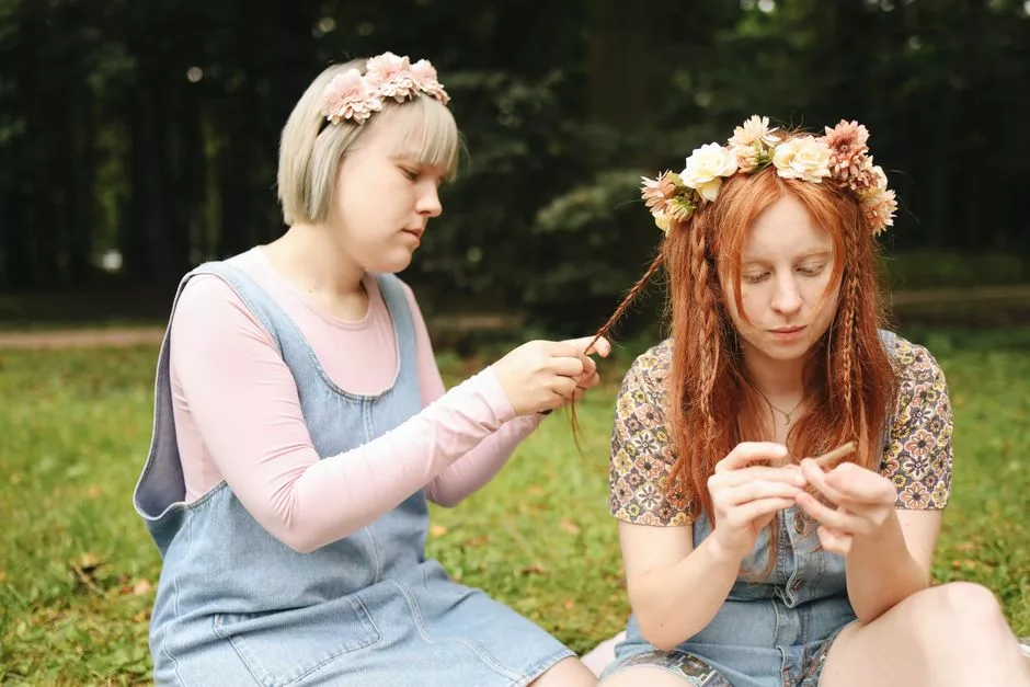 Deux femmes confectionnant des couronnes de fleurs en extérieur, atelier convivial