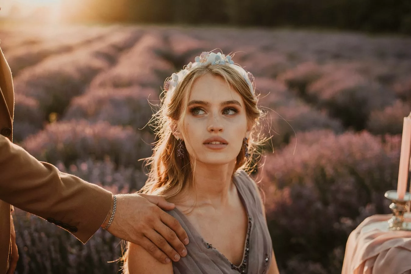 Mariée portant une couronne pastel dans un champ de lavande au coucher du soleil
