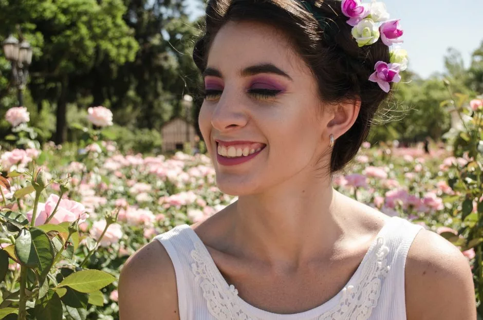Jeune femme souriante portant une couronne de roses dans un jardin printanier