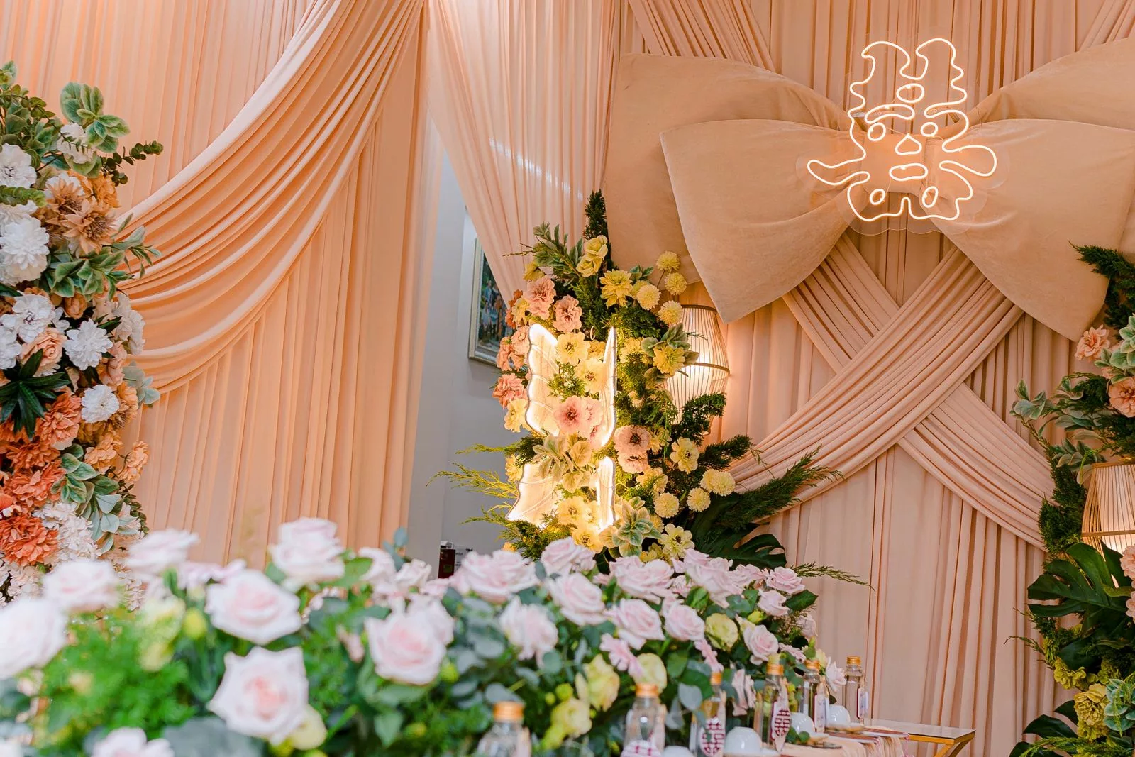 Décor de mariage pastel pêche avec drapé pastel et roses poudrées