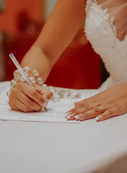 Mariée signant l'acte de mariage à la mairie lors de la cérémonie civile
