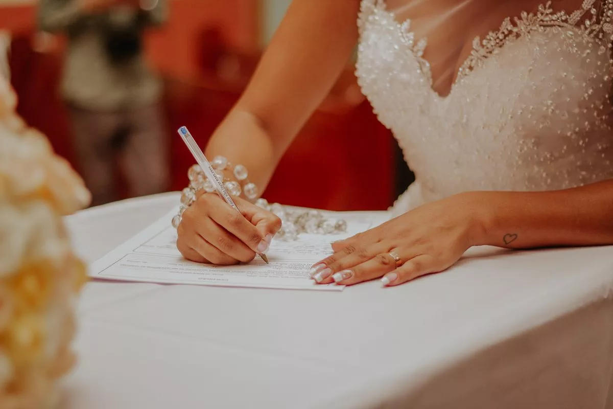 Mariée signant l'acte de mariage à la mairie lors de la cérémonie civile