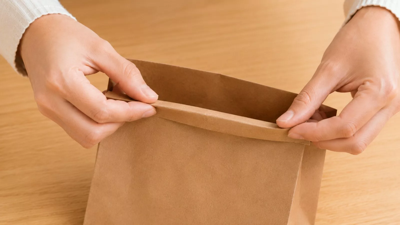 Replier le haut du sac en papier kraft vers l'intérieur pour former un rebord renforcé
