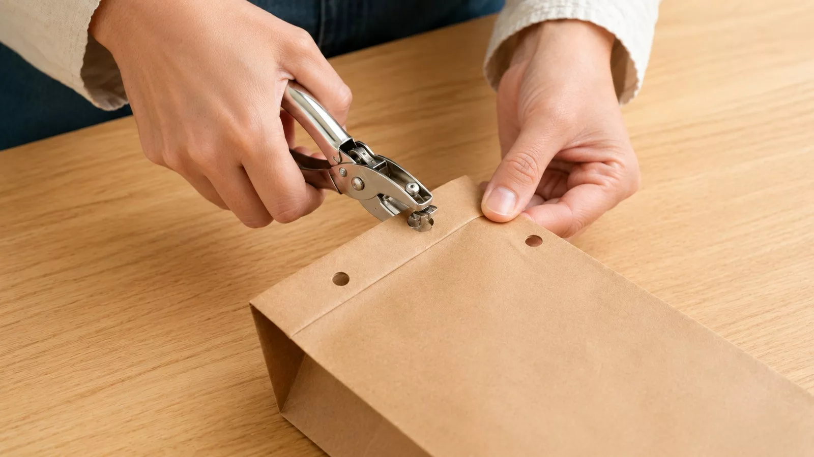 Percer les trous des anses dans le haut du sac avec une perforatrice