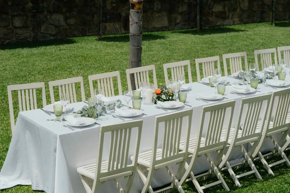 Grande table de réception de mariage décorée d'eucalyptus dans un jardin