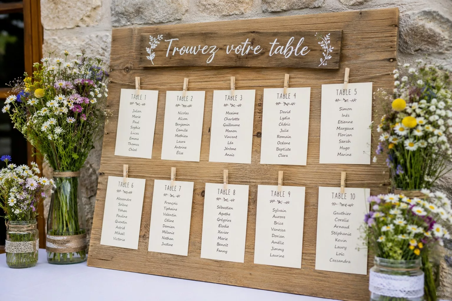 Plan de table de mariage champêtre en bois avec fleurs des champs dans des bocaux