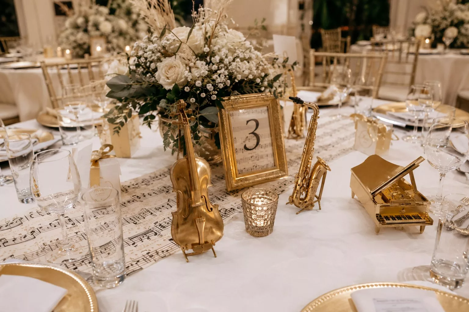 Décoration de table de mariage thème musique avec instruments miniatures dorés et numéro de table