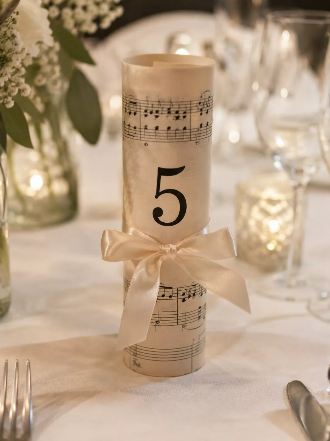 Numéro de table de mariage sur une partition roulée nouée d'un ruban