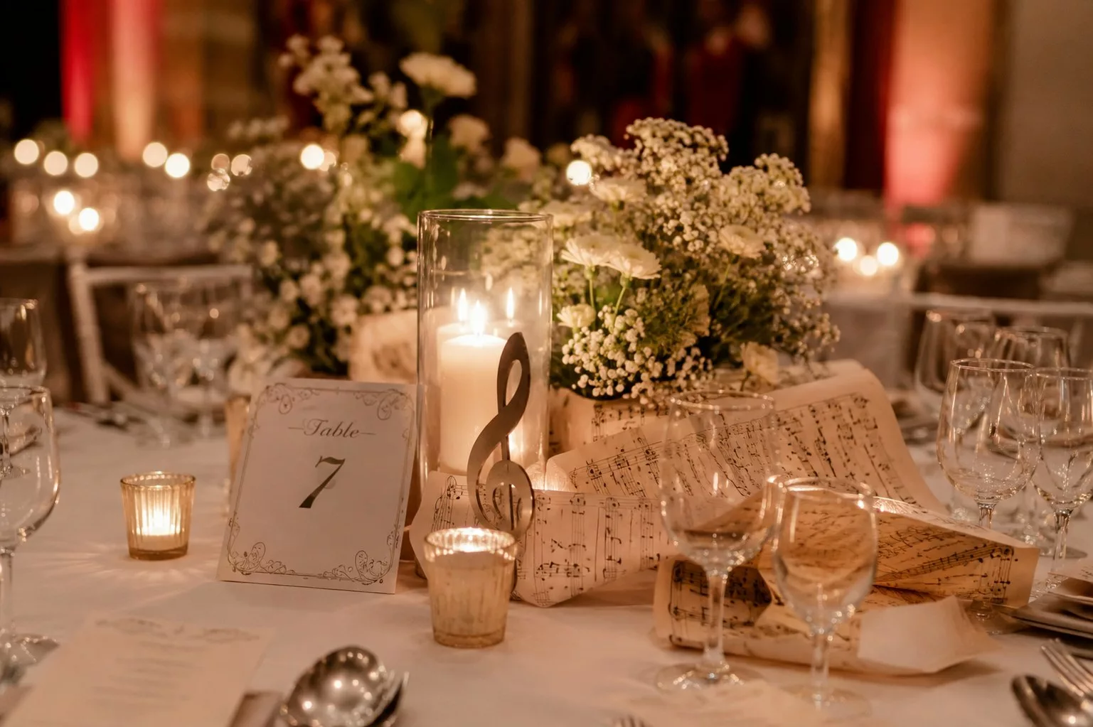 Table de mariage décorée de partitions, bougies et clé de sol avec numéro de table
