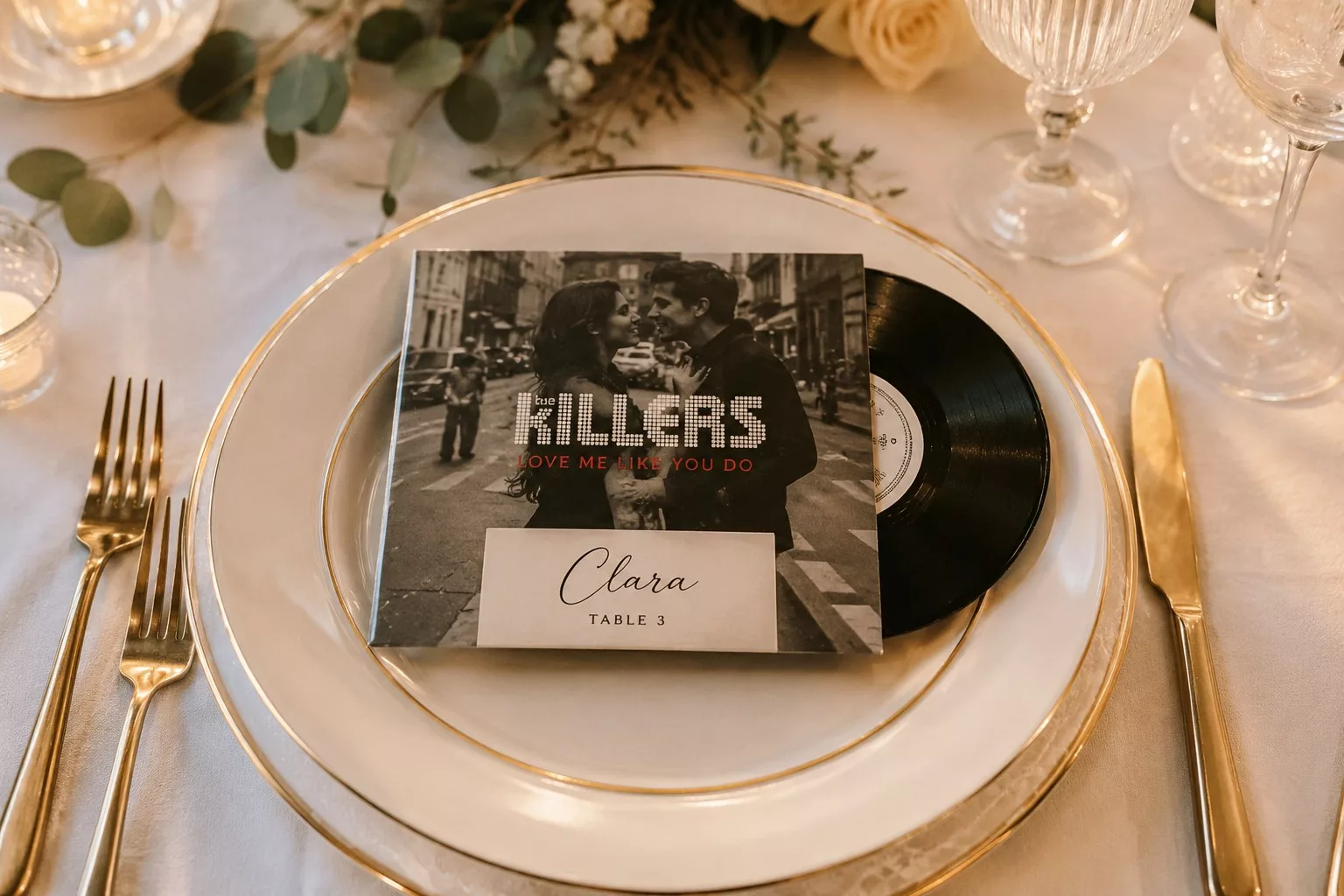 Pochette de disque vinyle posée sur l'assiette d'un set de table de mariage en guise de marque-place
