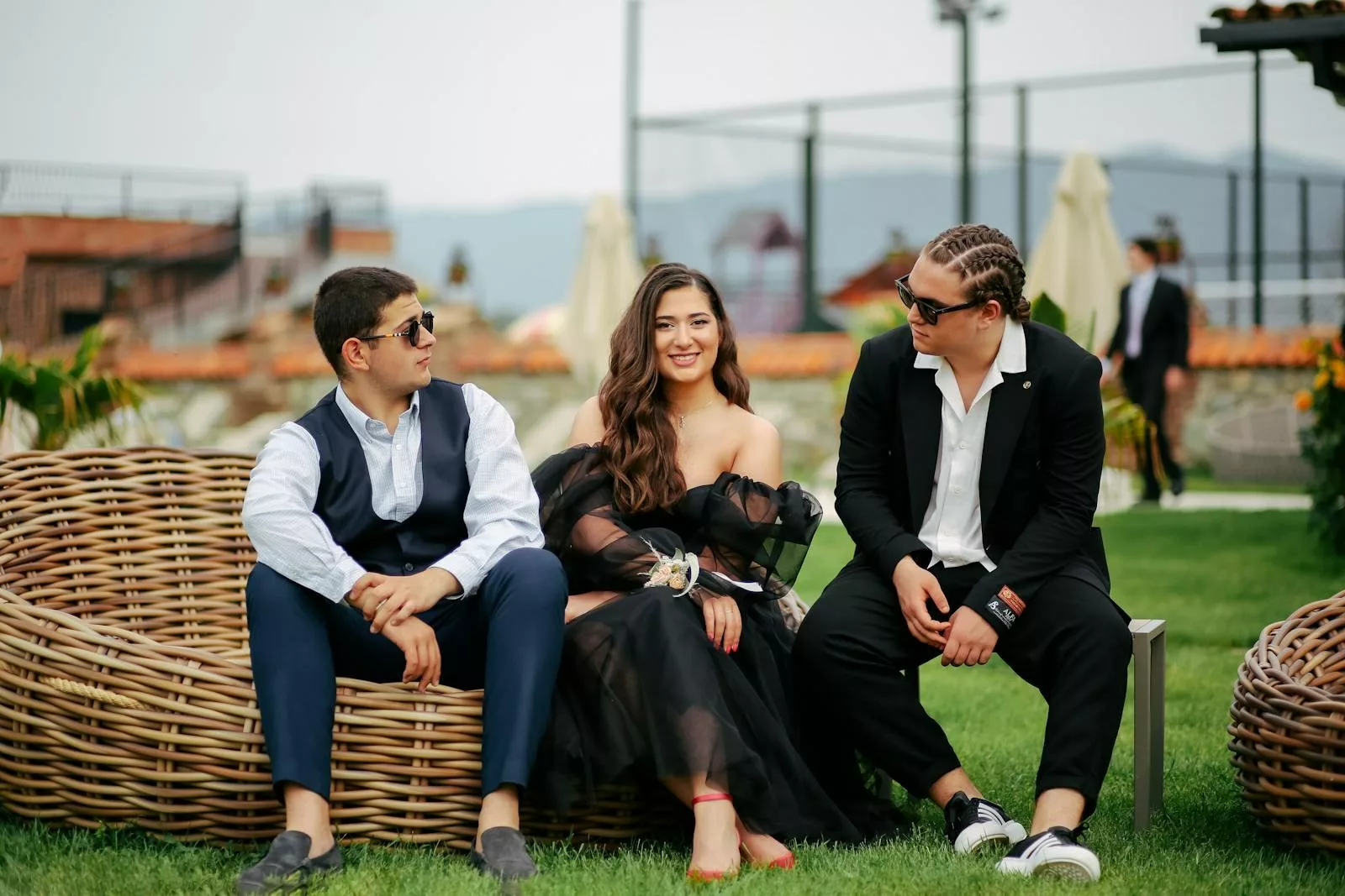Trois invitées élégantes à un mariage en extérieur
