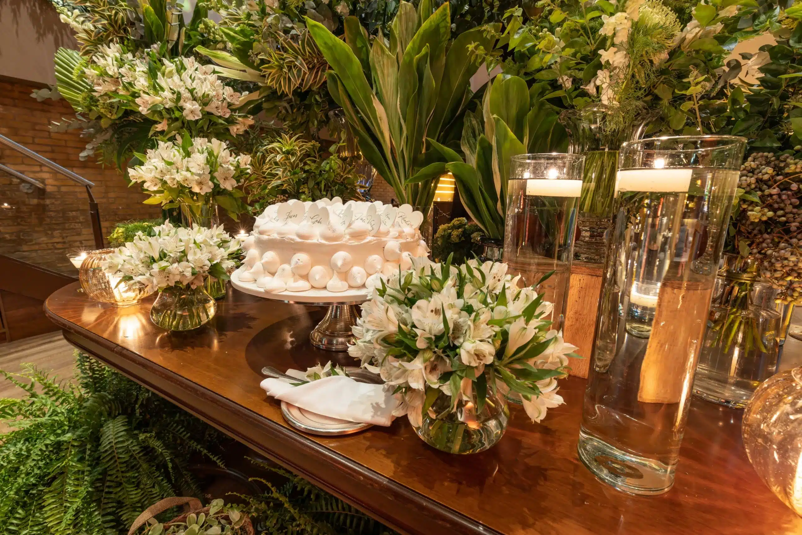 Grands vases cylindriques avec bougies flottantes en centre de table de mariage