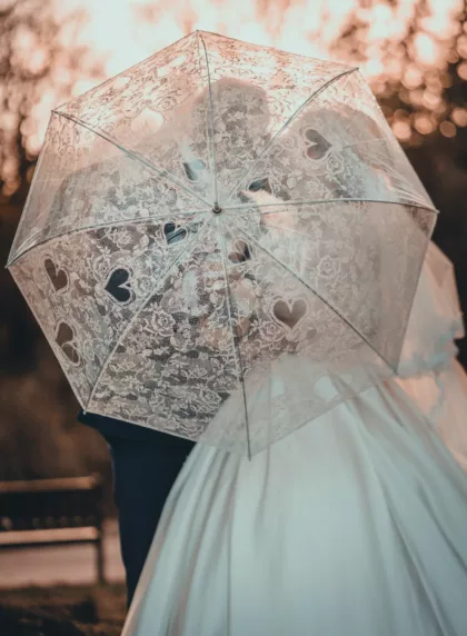 Mariés sous parapluie en dentelle au coucher de soleil, danse du parapluie mariage