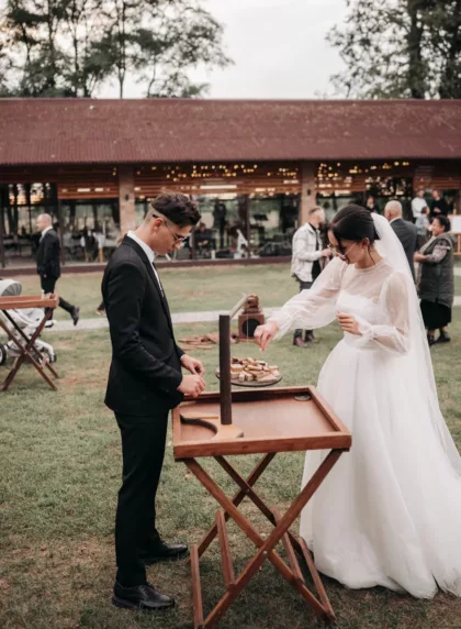 Couple de mariés jouant à un jeu de mariage en plein air pendant le vin d'honneur