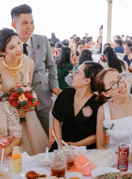 Groupe d'invités en train de faire un selfie avec les mariés pendant une réception de mariage