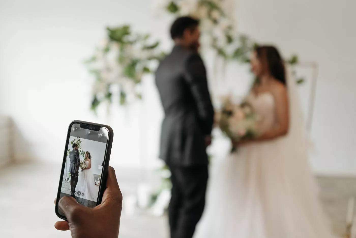 Invité tenant un smartphone pendant une cérémonie de mariage