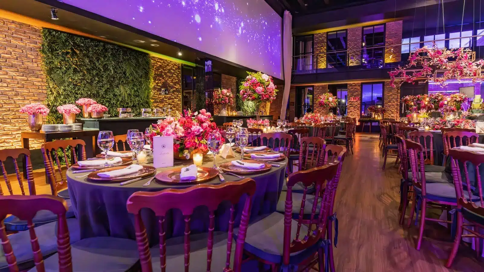 Salle de réception mariage prestige avec fleurs roses vibrantes et éclairage travaillé