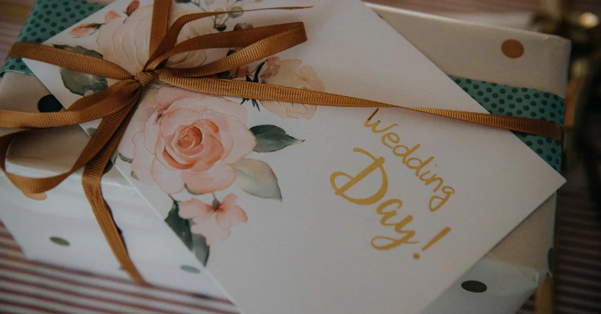 Cadeau de mariage emballé dans un papier floral avec ruban doré et carte Wedding Day