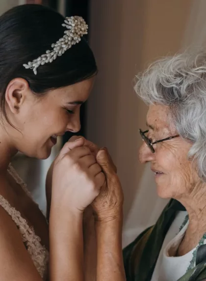 Grand-mère de 70 ans tenant tendrement les mains de la mariée le jour du mariage